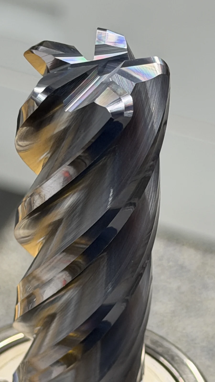 Macro photo of a RobbJack SPS Super Python variable-helix carbide end mill with dark AlTiN coating